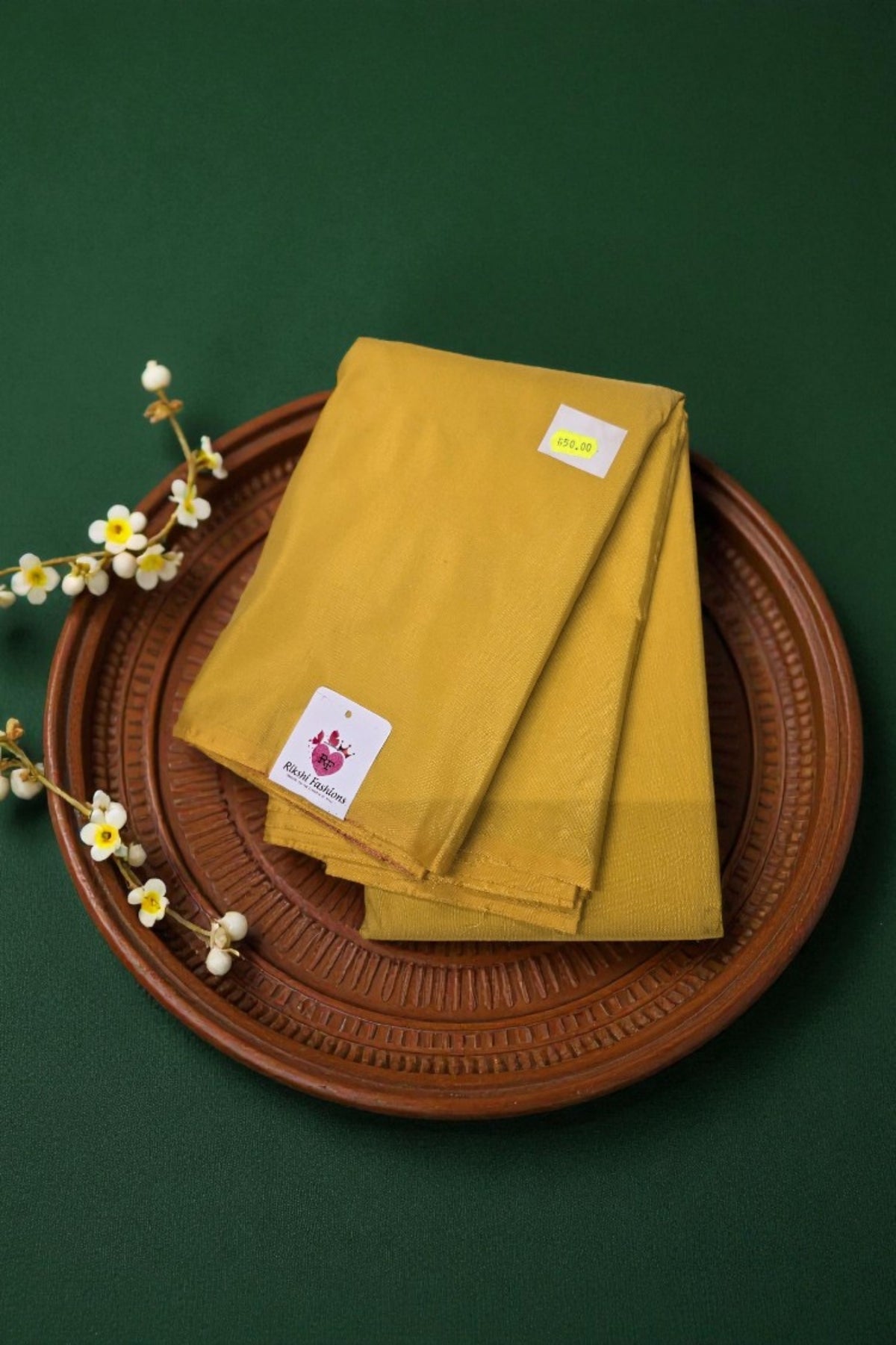 Mustard yellow napkins on a brown woven tray with a green background