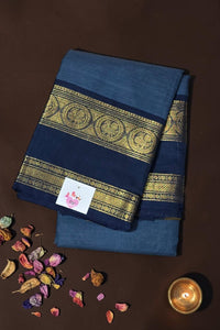 Blue saree with gold border on a brown background