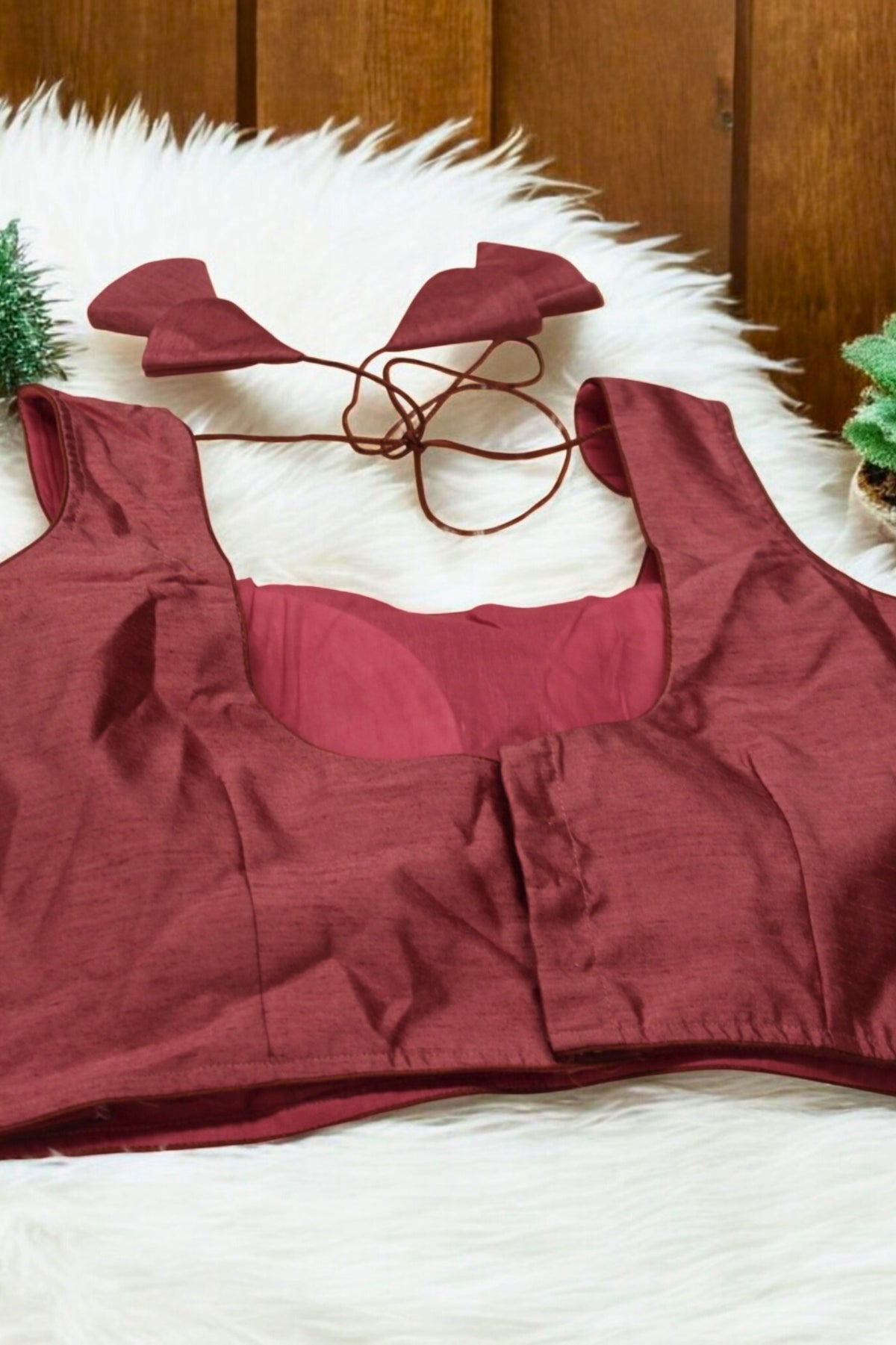 Red bikini set on a white surface with a wooden panel background