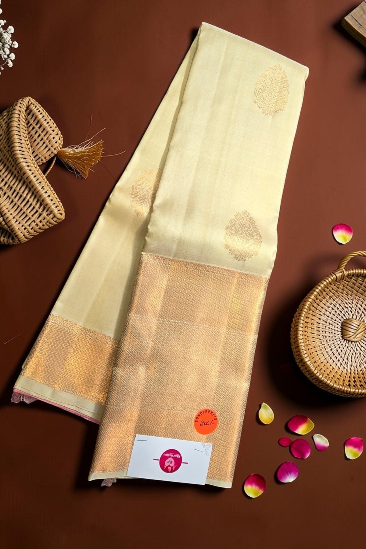 Beige saree with gold border on a brown background
