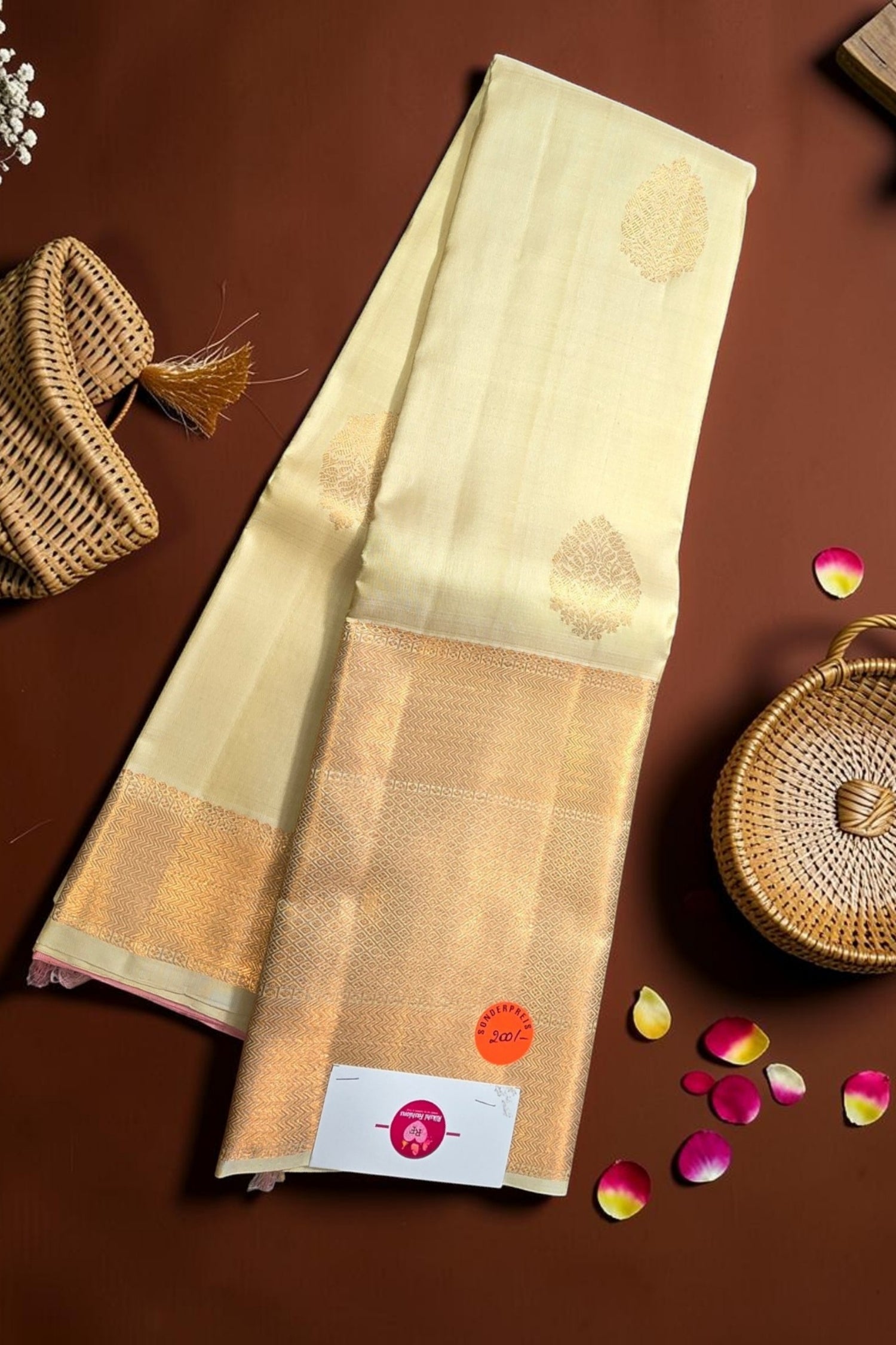 Beige saree with gold border on a brown background