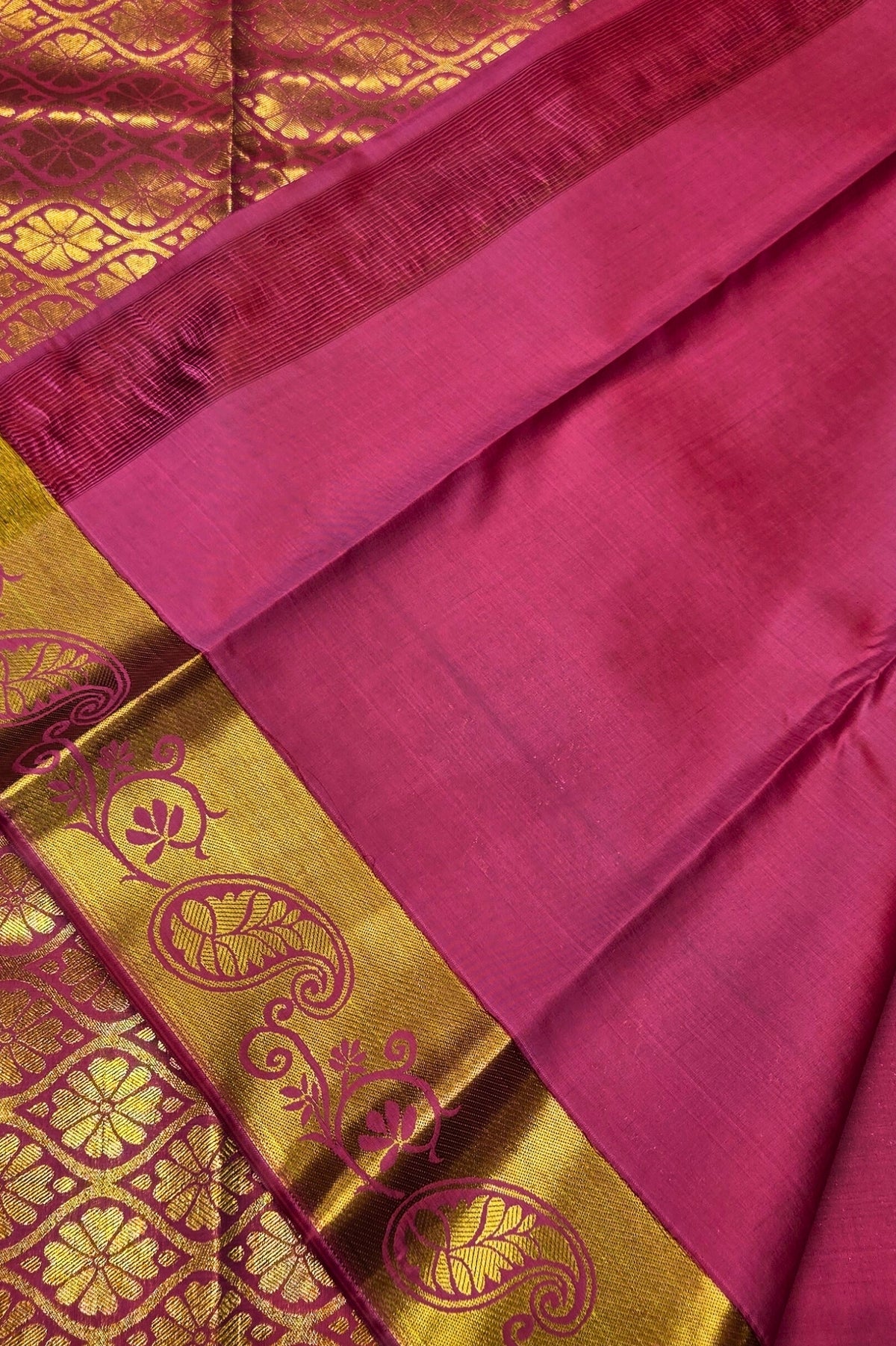 Pink fabric with gold embroidery on a red background