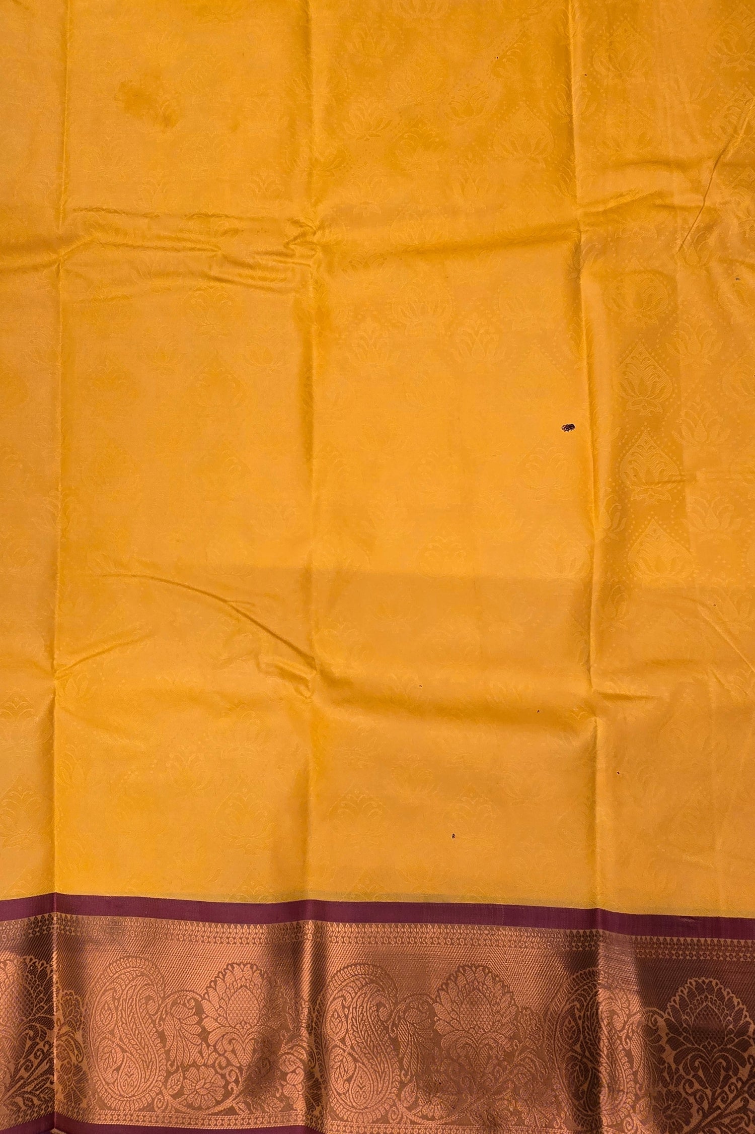 Yellow fabric with a purple border featuring intricate patterns