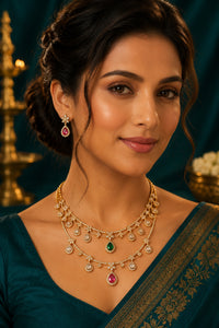 Woman wearing a green saree with gold jewelry against a dark background