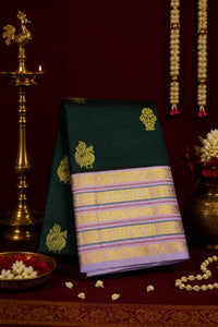 Traditional green and purple saree with gold patterns on a dark red background