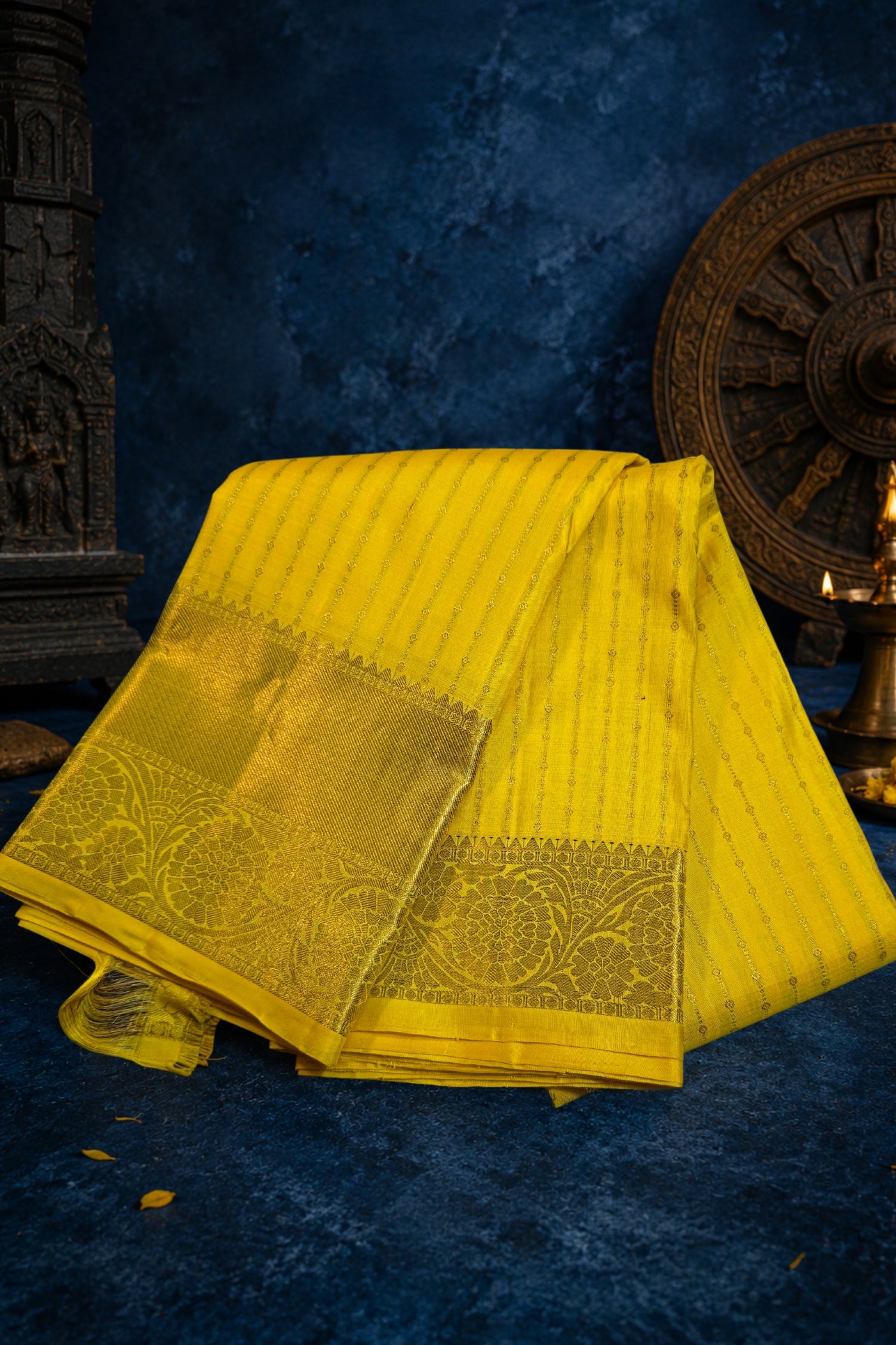 Bright yellow silk saree with gold border and subtle vertical stripes, perfect for festive occasions.