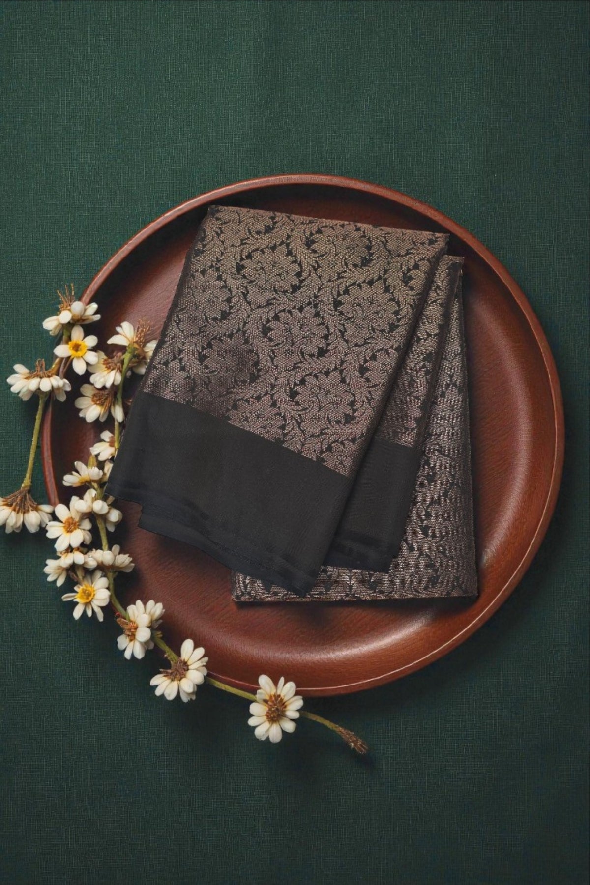 Two scarves on a brown plate with flowers on a green background