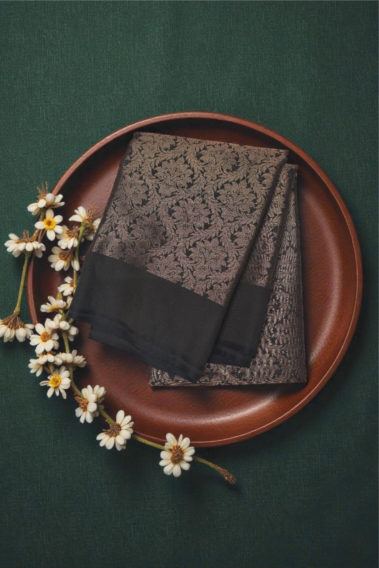 Two scarves on a brown plate with flowers on a green background