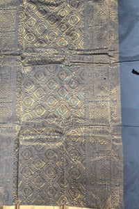 Textile with gold geometric pattern on a dark background