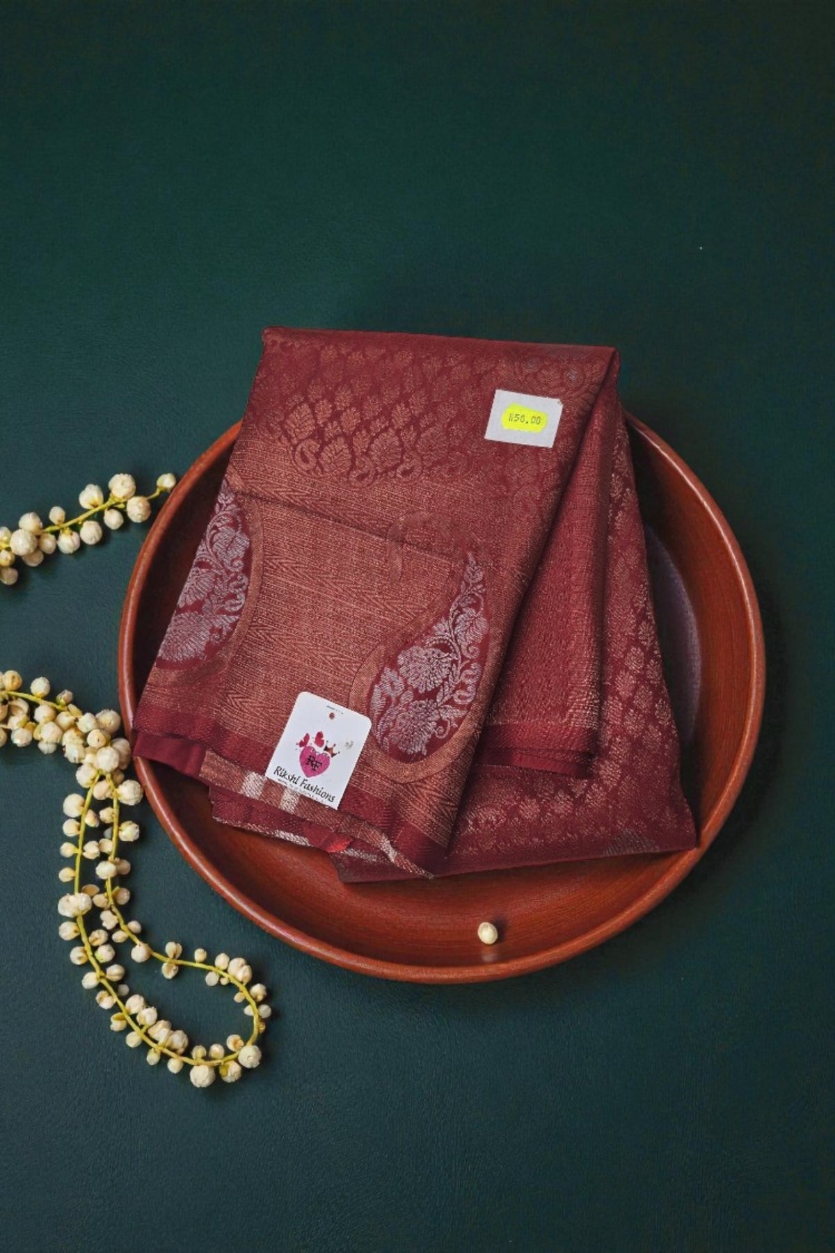 Red embroidered fabric on a brown plate with a dark green background