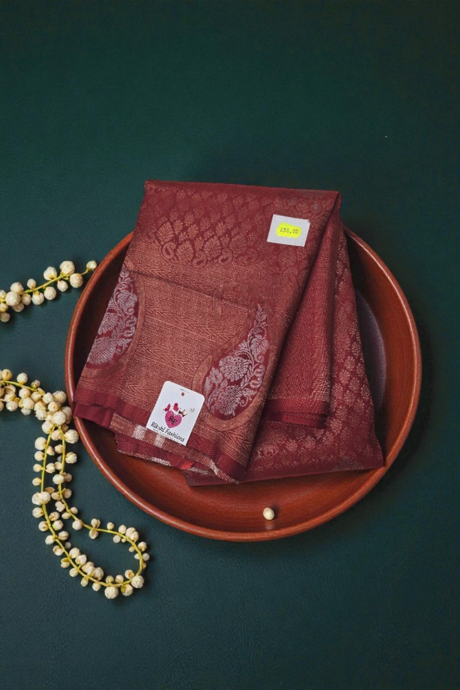 Red embroidered fabric on a brown plate with a dark green background