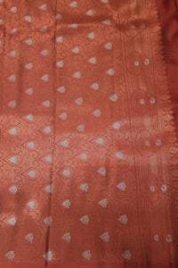 Textured fabric with a subtle pattern on a reddish-brown background