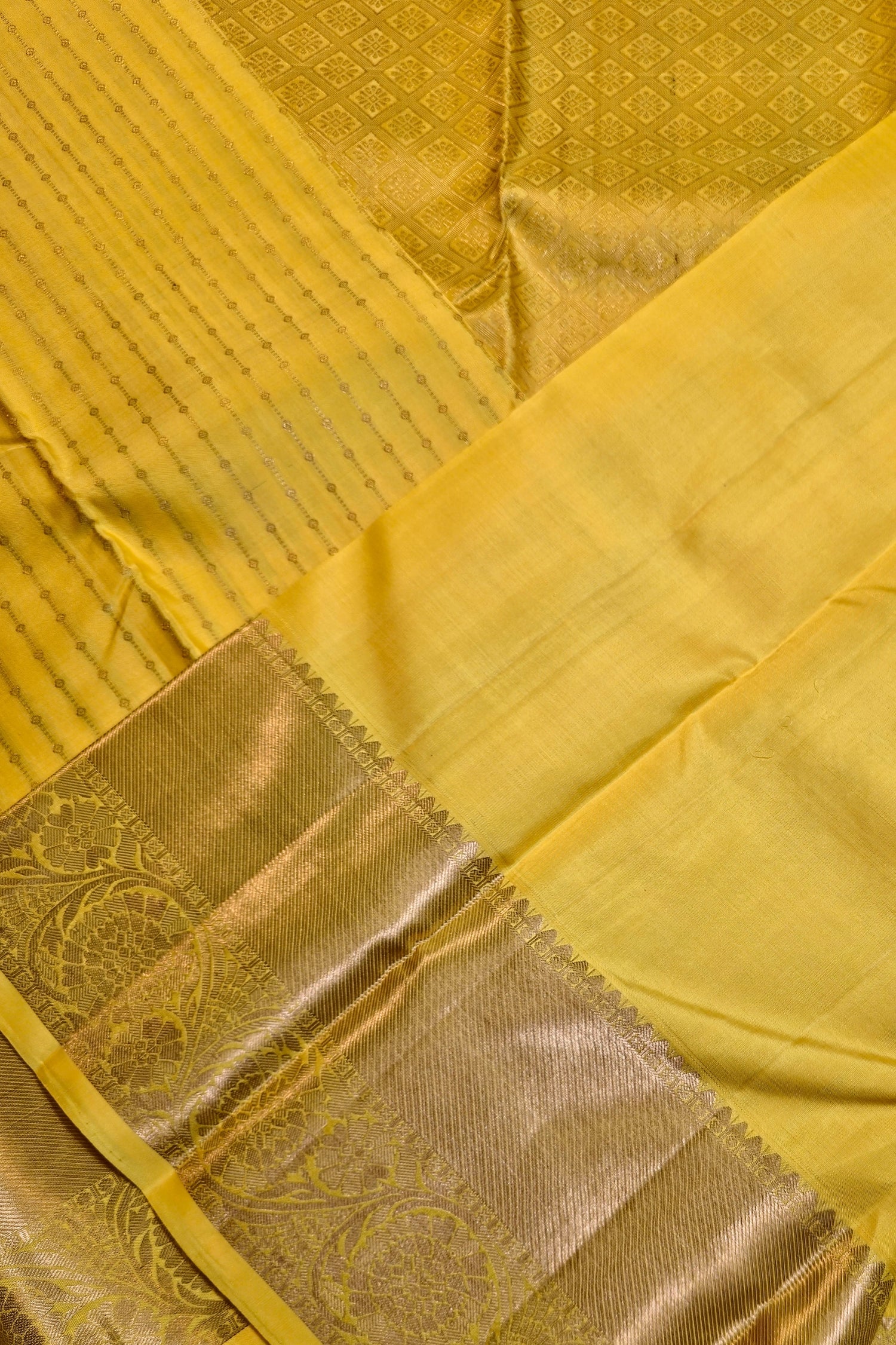 Bright yellow silk saree with gold border showcasing wide metallic border and subtle vertical stripes.