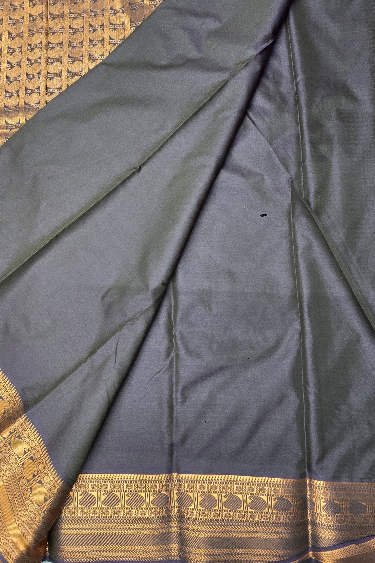 Dark blue fabric with gold border on a textured surface