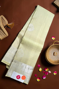 Light green fabric with white floral patterns on a brown surface with wicker baskets and rose petals.