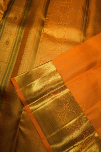 Close-up of a golden zari silk saree with a vibrant orange border and intricate woven patterns.