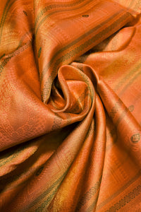 A close-up of draped orange fabric with a subtle woven pattern and a warm golden sheen.