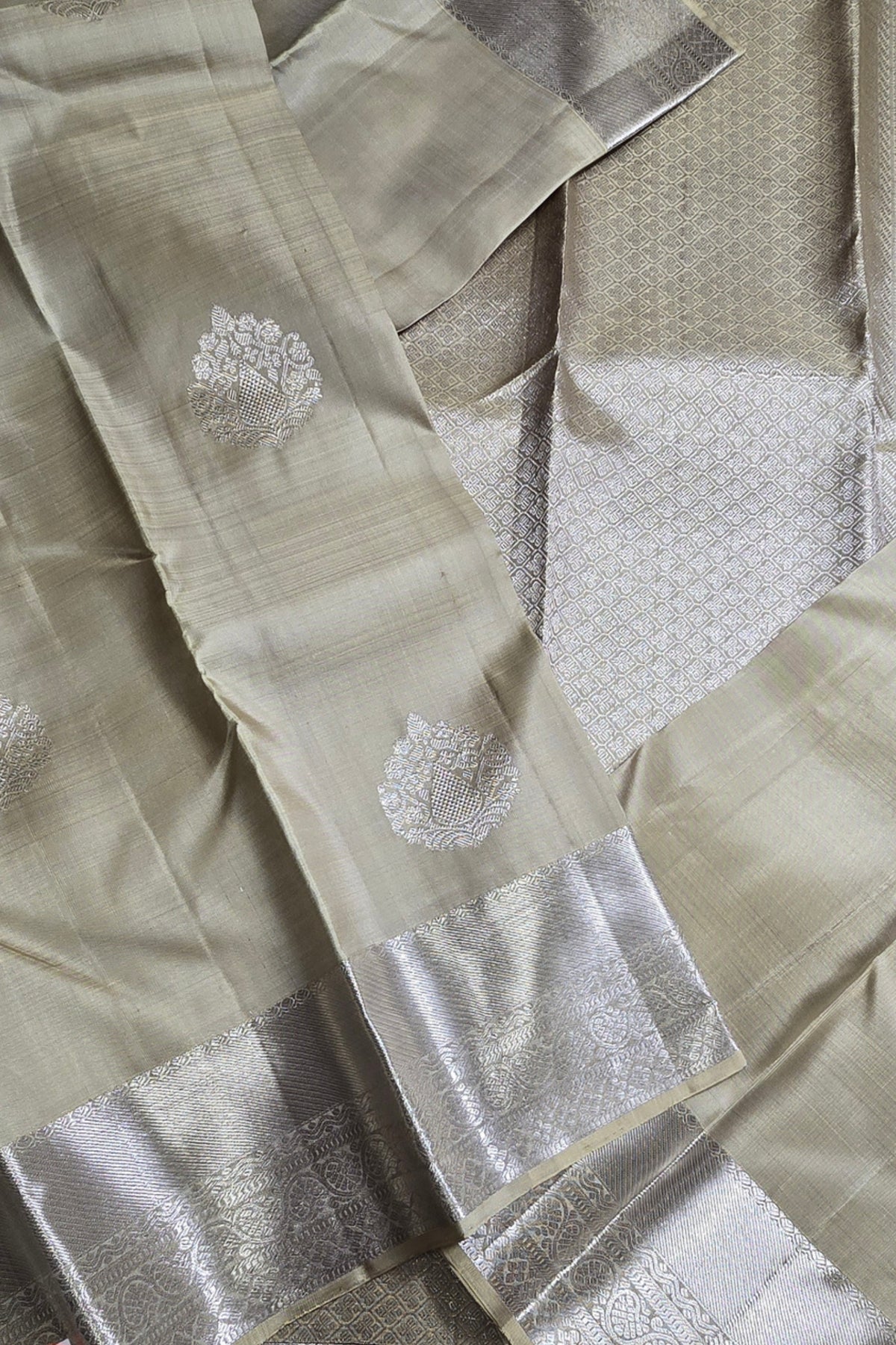 Close-up of a light green saree with silver embroidery and border