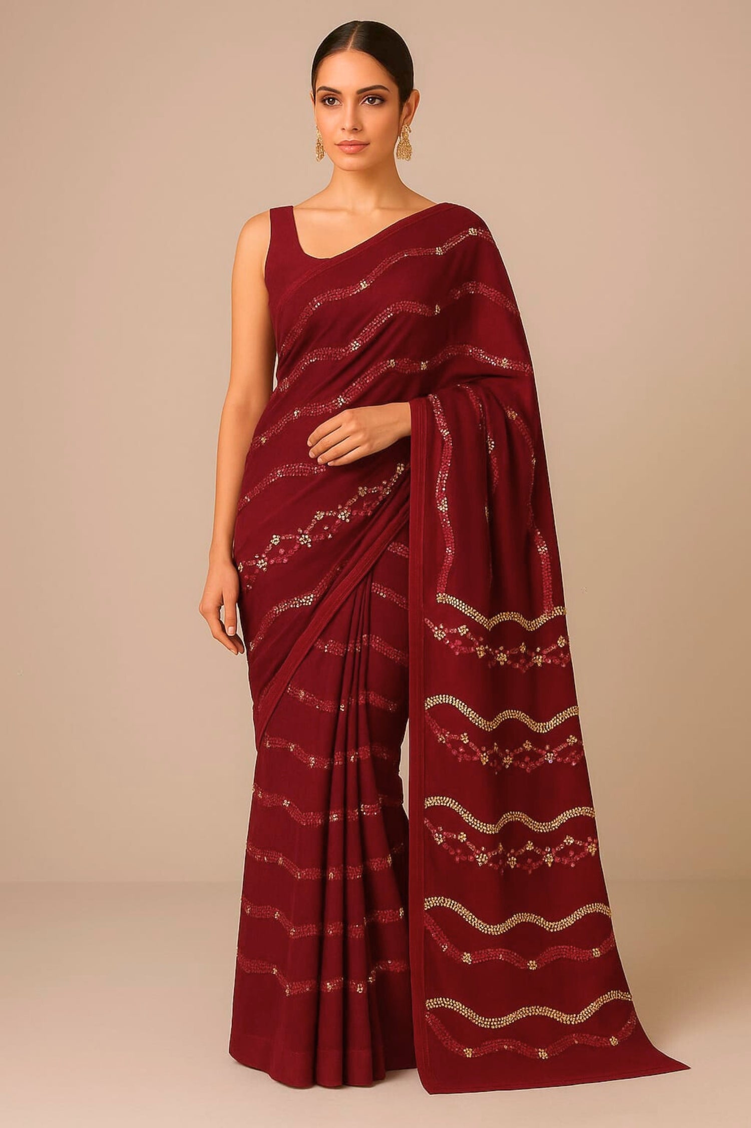 Woman wearing a maroon saree with white patterns on a beige background