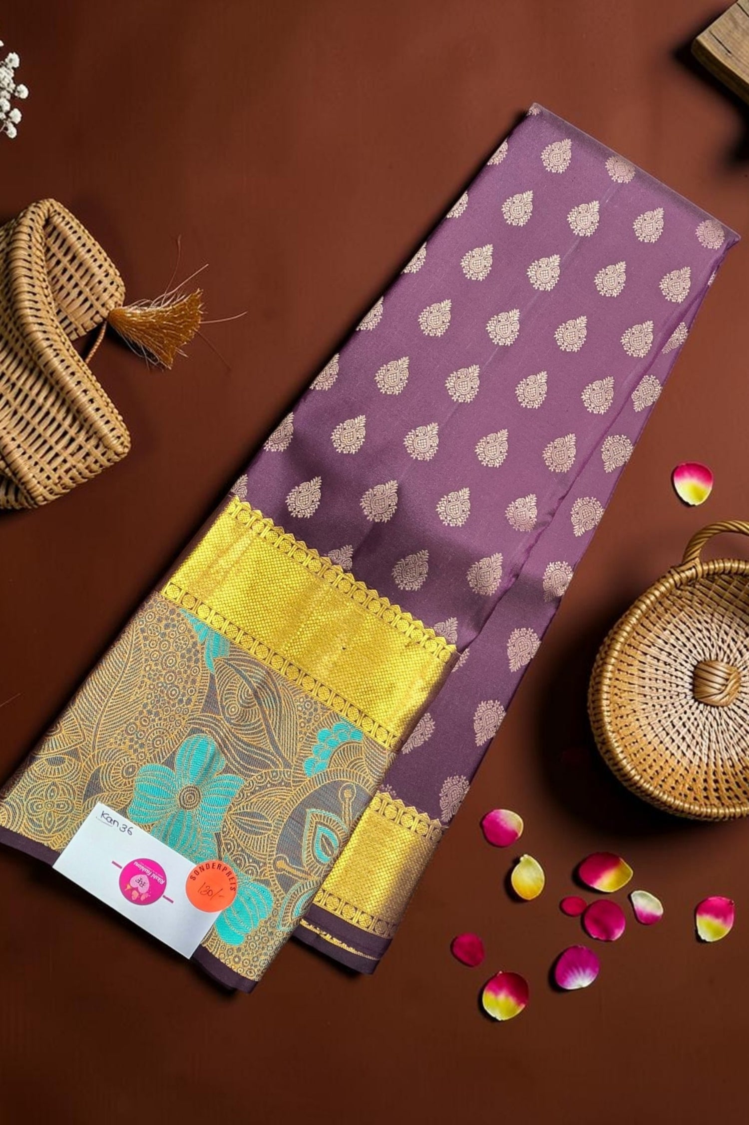 Purple fabric with gold patterns on a brown surface with decorative elements