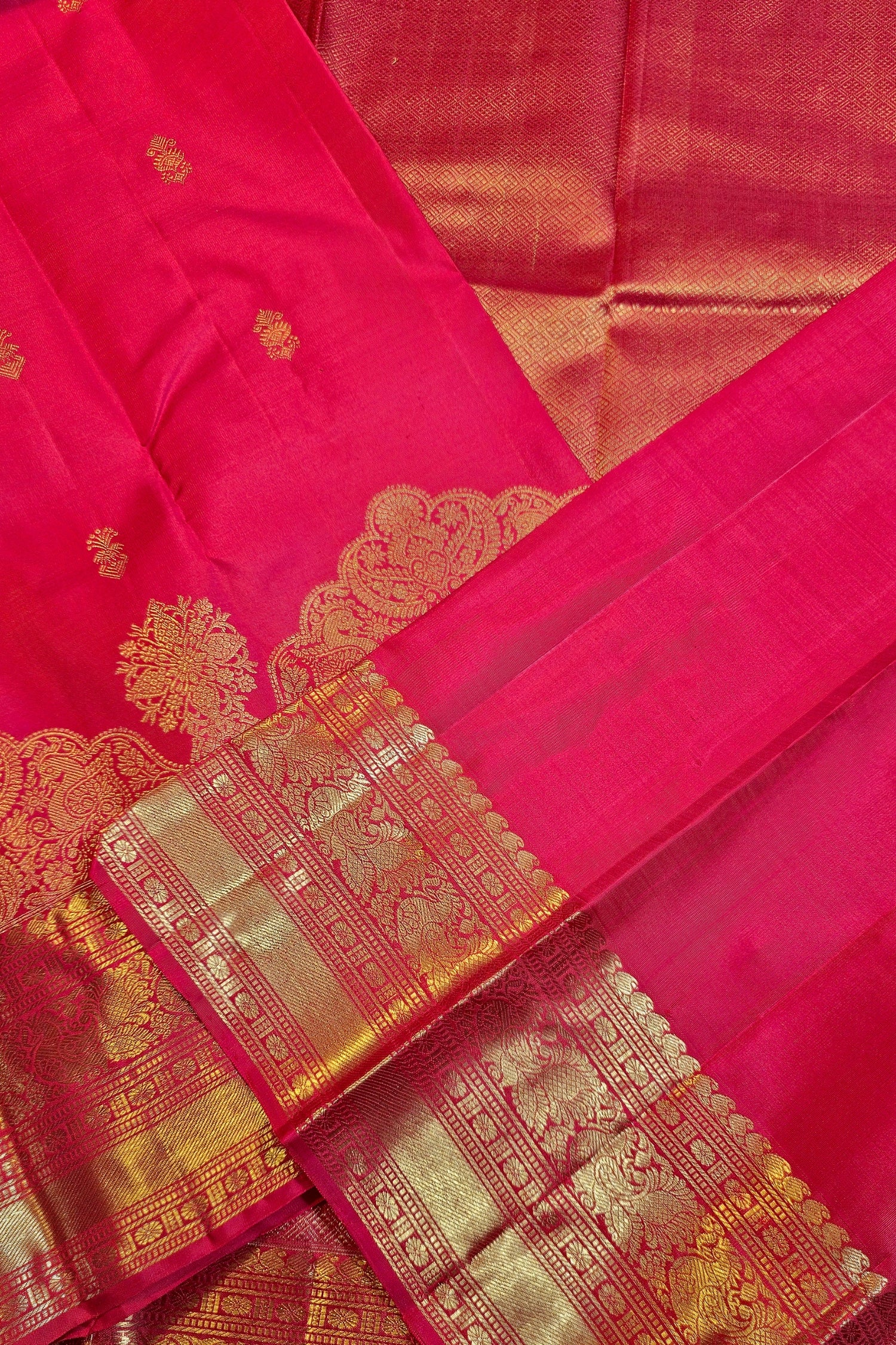 Crimson red silk saree with gold zari brocade featuring intricate designs and luxurious fabric.