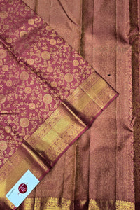 Brown and gold traditional saree with a visible brand label.