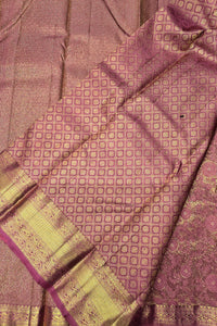 Close-up of a pink and gold patterned fabric with a textured surface.