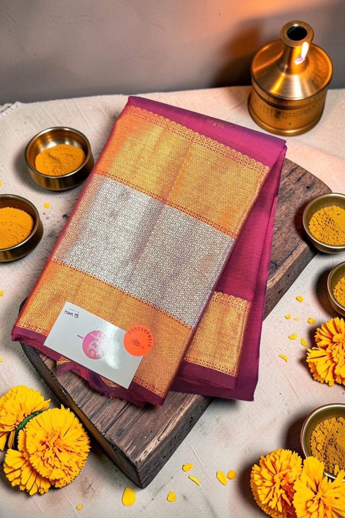 Traditional saree with a card on a wooden board surrounded by decorative elements