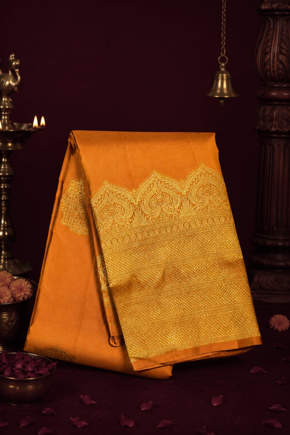 Orange saree with gold patterns on a dark background