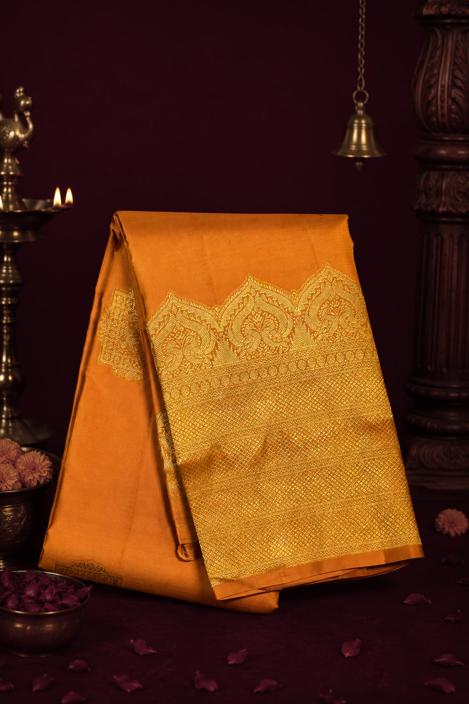 Orange saree with gold patterns on a dark background