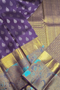 Purple fabric with white patterns and gold border, alongside a textured brown fabric.