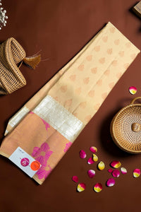 Beige fabric with floral patterns on a brown surface with wicker baskets and flower petals.
