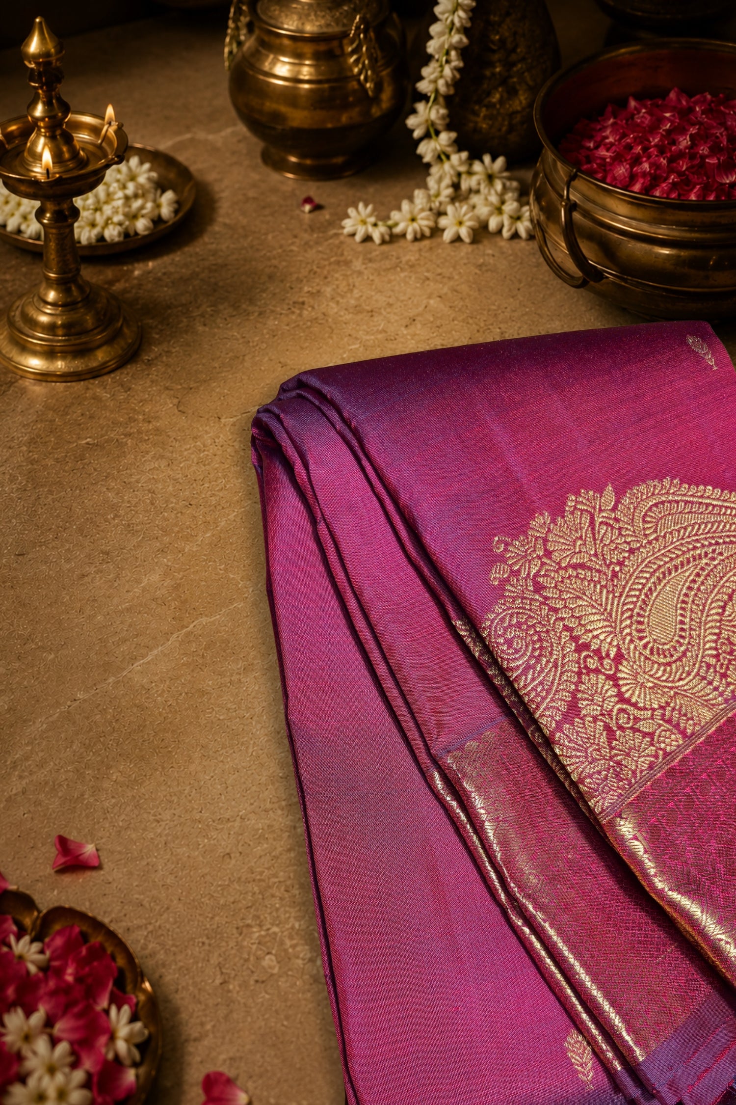 Maroon dual tone silk saree with intricate gold zari brocade work on a stylish display for festive occasions.
