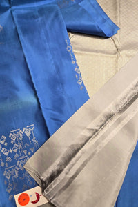 Close-up of blue and gray fabric with intricate patterns on a textured surface.