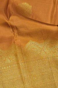 Close-up of a brown fabric with intricate gold embroidery