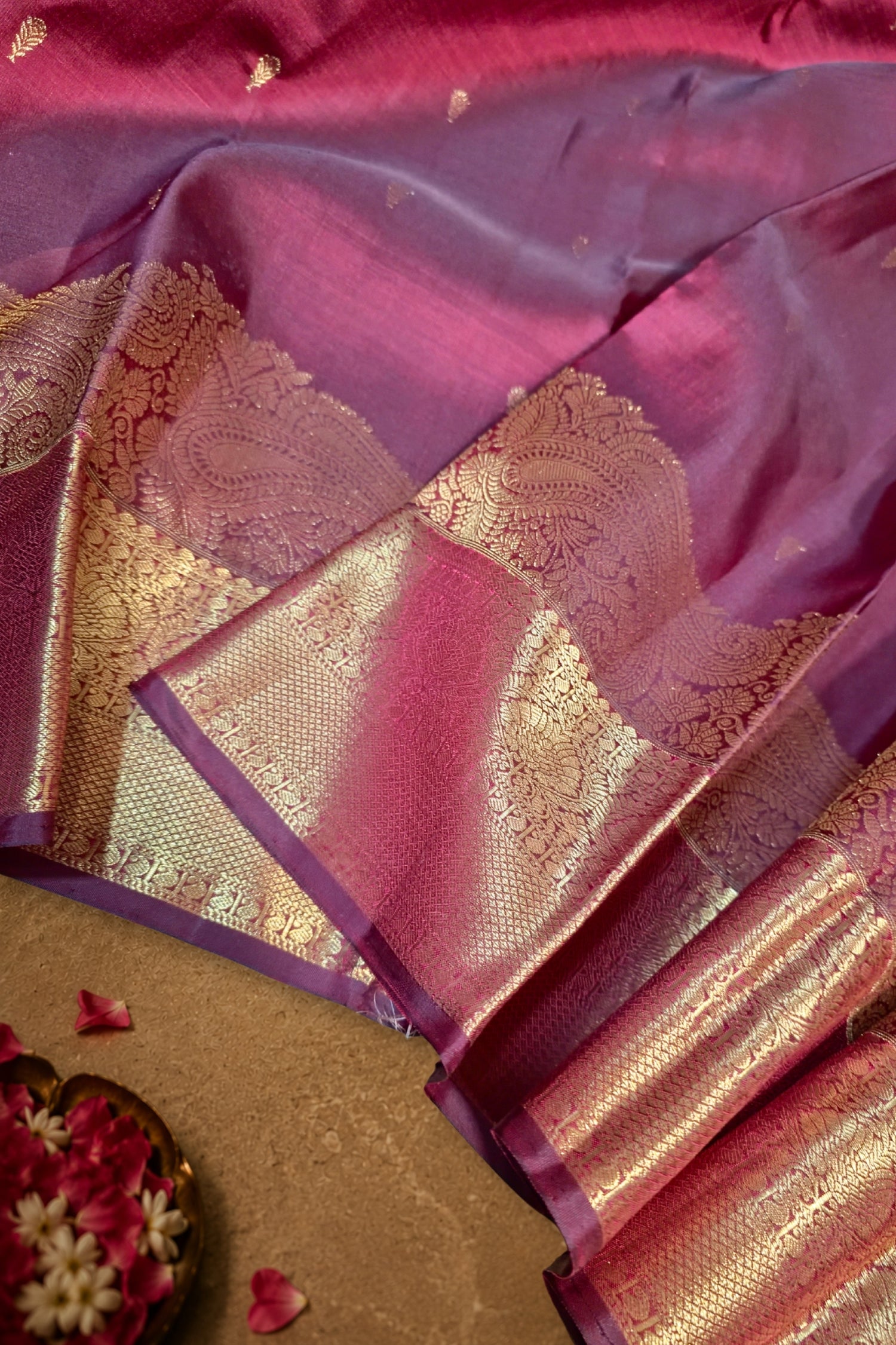 Maroon dual tone silk saree with intricate gold zari brocade work and small gold motifs.