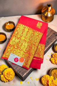 Red and gold saree with decorative elements on a wooden board