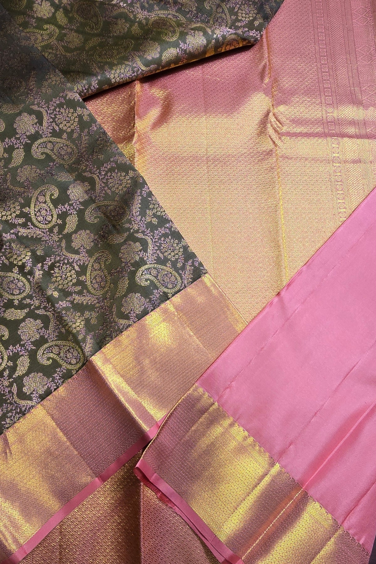 Close-up of a fabric with pink, gold, and green patterns