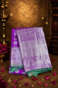 Purple and silver saree with floral decorations on a brown background