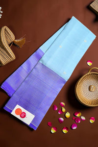 Blue and purple fabric with a woven basket and flower petals on a brown background