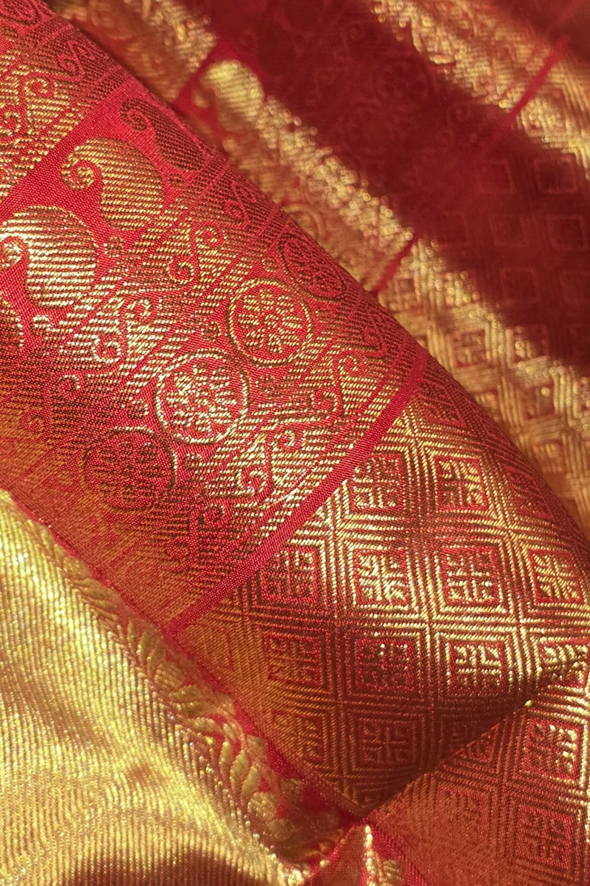 Close-up of a red and gold patterned fabric with intricate designs.