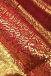 Close-up of a red and gold patterned fabric with intricate designs.