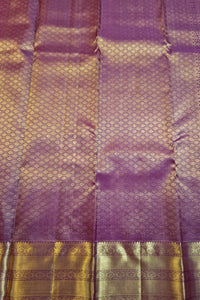 Purple silk saree fabric with intricate gold zari woven patterns and a wide decorative gold border.