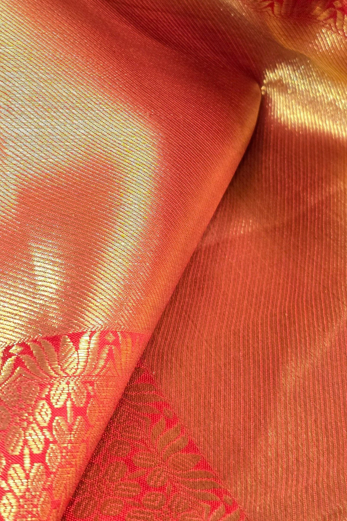 Close-up of orange fabric with red and gold pattern