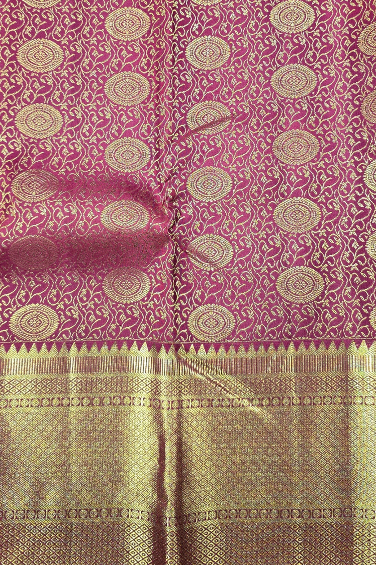 Pink and gold patterned fabric with a visible brand name.