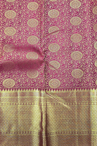 Pink and gold patterned fabric with a visible brand name.