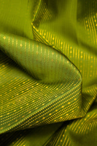 Green saree with gold zari border fabric close-up showing intricate patterns.