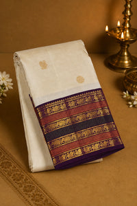 White saree with a colorful border featuring elephants on a brown background