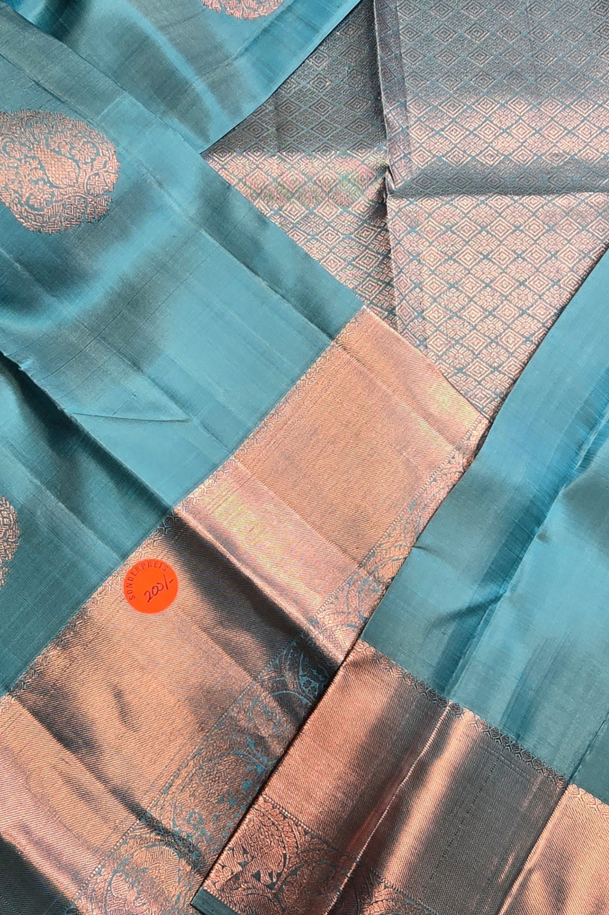 Close-up of a fabric with teal, brown, and gray patterns