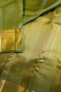 Green saree with gold zari border showcasing intricate patterns and luxurious texture.